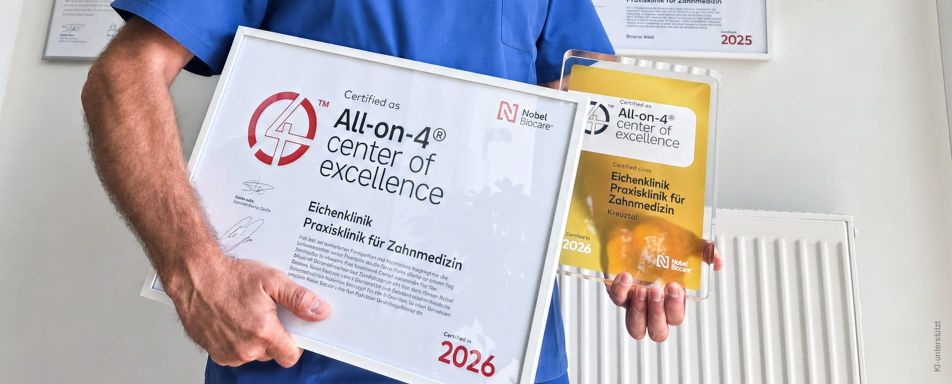 Ein Arzt hält zwei Zertifikate für die All-on-4® Exzellenz in der Zahnmedizin in einer modernen Klinik.